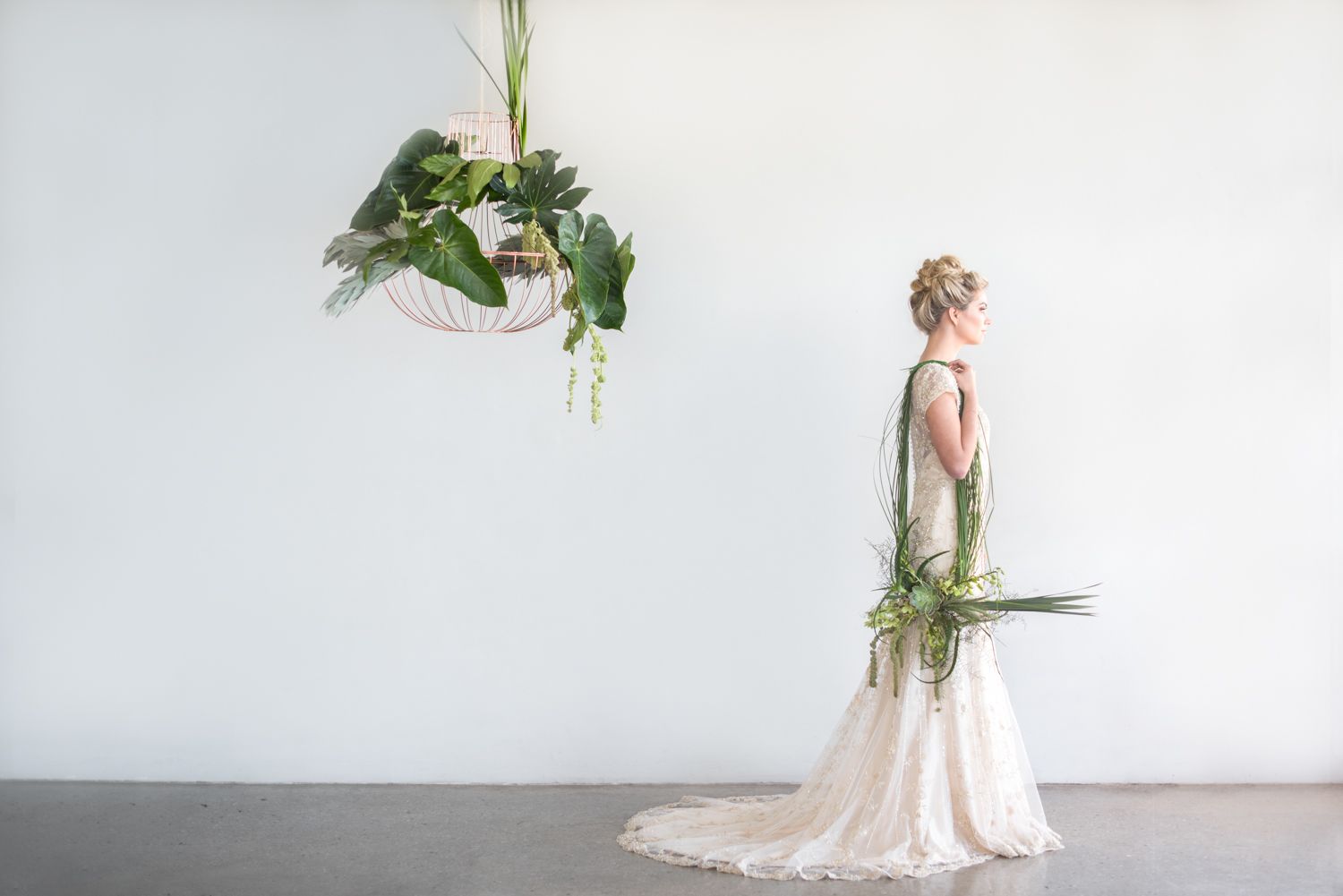 Bride in cream lace dress with botanical greenery bouquet in minimalist setting