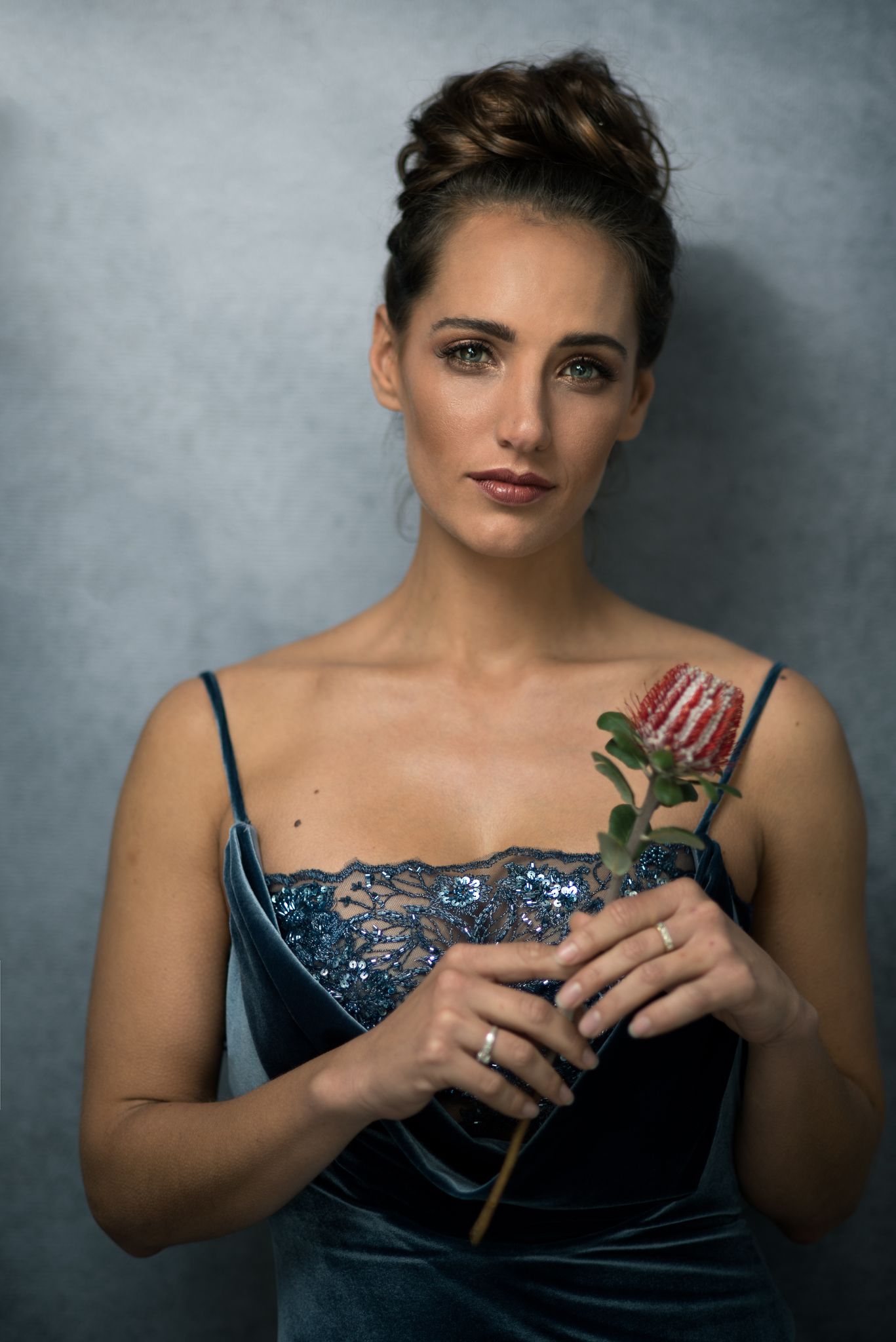 Woman in a blue velvet dress holding a protea flower — South African portrait photography in Cape Town