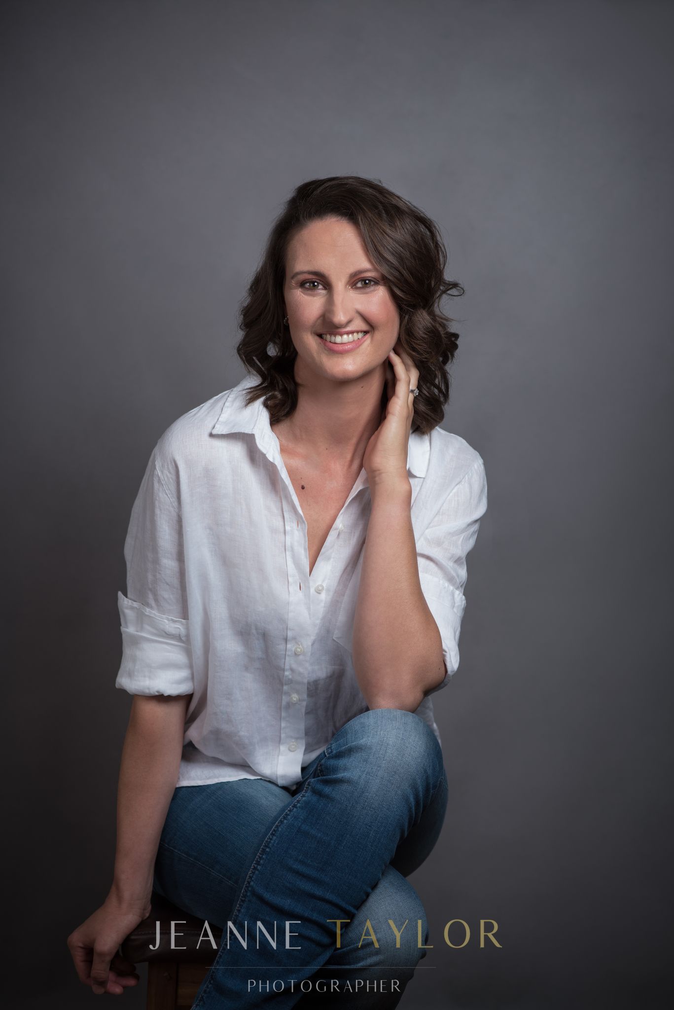 Woman in a white shirt smiling naturally with curly hair — natural portrait photography in Cape Town